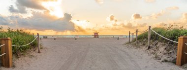Güneşin doğuşunda okyanus geçmişiyle Miami Beach Florida sahiline giden yol.