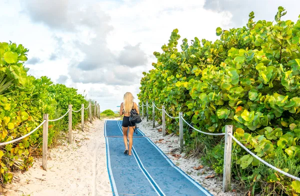 Mädchen zu Fuß zum Strand auf einem Fußweg. Südstrand in miami, florida, usa — Stockfoto