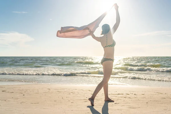Mujer de pie con toalla en la playa con el océano en el fondo —  Fotos de Stock