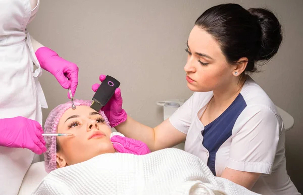 两名美容师同时为一位病人做面部护理 — 图库照片