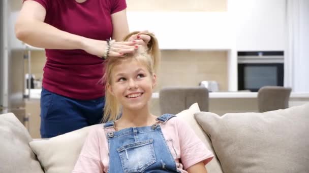 Levágott kezek Anya, hogy a lánya lófarok frizura és zsemle, lassított felvétel — Stock videók