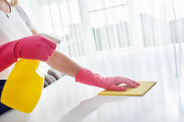 Женщина чистит домашний стол, дезинфицирует поверхность кухонного стола с помощью дезинфицирующего баллончика — стоковое фото