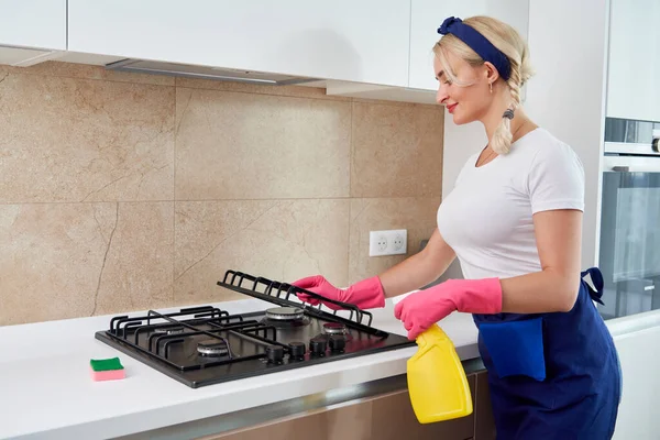 Het reinigen van een gasfornuis met keukengerei, huishoudelijke concepten, of hygiëne en reiniging. — Stockfoto