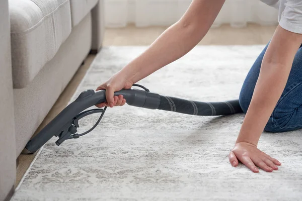 Concetto di casa e lavori domestici donna felice o casalinga con aspirapolvere pavimento sotto il divano a casa — Foto Stock