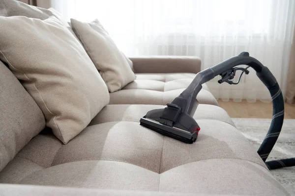 Staubsauger auf einem Sofa im leeren Wohnzimmer einer modernen Wohnung — Stockfoto