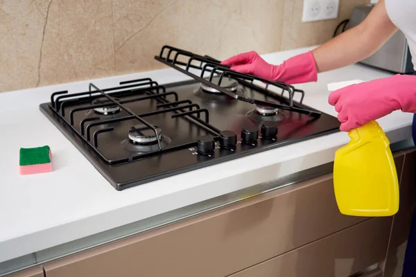 Чистка газовой плиты с кухонной утварью, бытовой техникой, гигиеной и уборкой. — стоковое фото