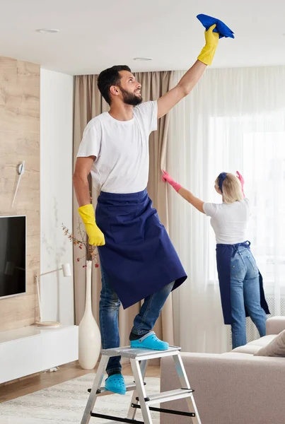 El equipo de servicio de limpieza profesional limpia la sala de estar en un apartamento moderno — Foto de Stock