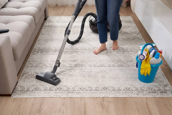 Frau putzt Teppich mit Staubsauger im Wohnzimmer — Stockfoto