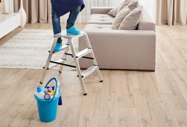 Cropped view of man climbing ladder to clean ceiling. Cleaning service concept