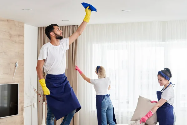 El equipo de servicio de limpieza profesional limpia la sala de estar en un apartamento moderno — Foto de Stock