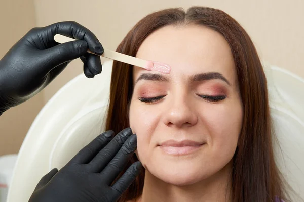 Pretty girl getting brow waxing in beauty salon — Stock Photo, Image