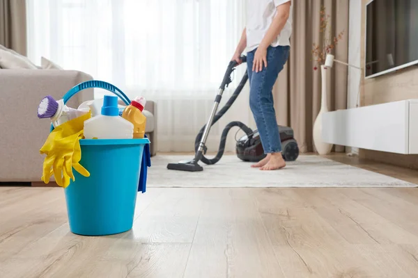 Mujer limpiando la alfombra con aspiradora en la sala de estar — Foto de Stock