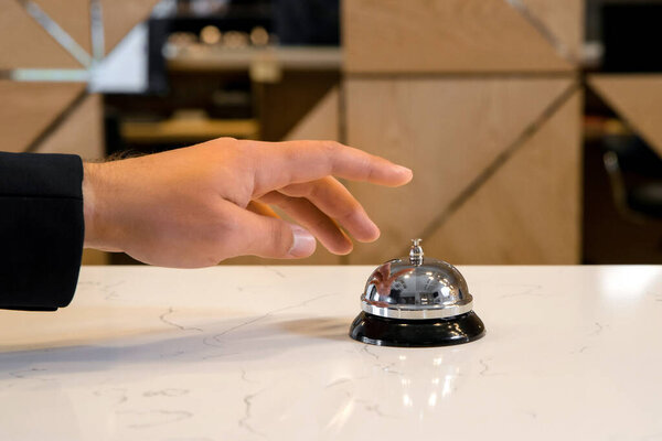 Hand of a man is going to use a vintage hotel bell