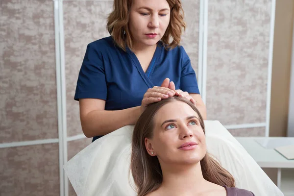 Beautiful Young Woman Getting a Face and head Treatment at Beauty Salon — Stock Photo, Image