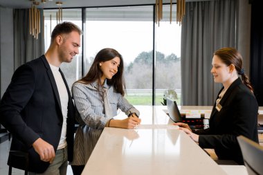 Oteldeki resepsiyonist ve çift. Genç bir çift iş gezisinde otele giriş yapıyor.