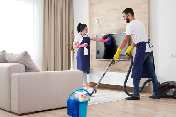 Profesyonel temizlik ekibi modern apartmandaki oturma odasını temizliyor. — Stok fotoğraf