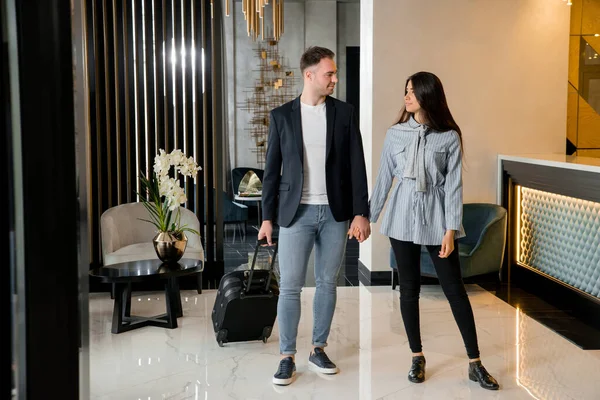 Junges Paar verabschiedet sich vor Mann in Hotellobby — Stockfoto