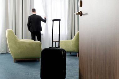 Otel odasında dikiz aynasından bakan koyu renk takım elbiseli işadamlarının...