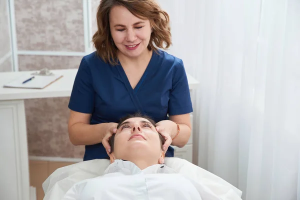 Beautiful Young Woman Getting a Face and head Treatment at Beauty Salon — Stock Photo, Image