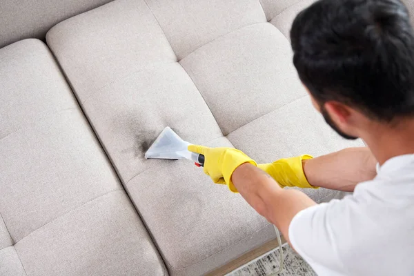 Närbild av hushållerskan håller modern tvätt dammsugare och rengöring smutsig soffa med professionellt tvättmedel. Professionell springclean hemma koncept — Stockfoto