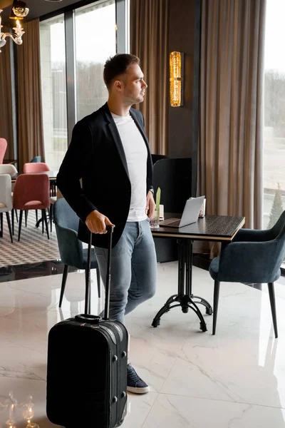 Junger Mann mit Reisetasche läuft in Lobby eines modernen Hotels — Stockfoto