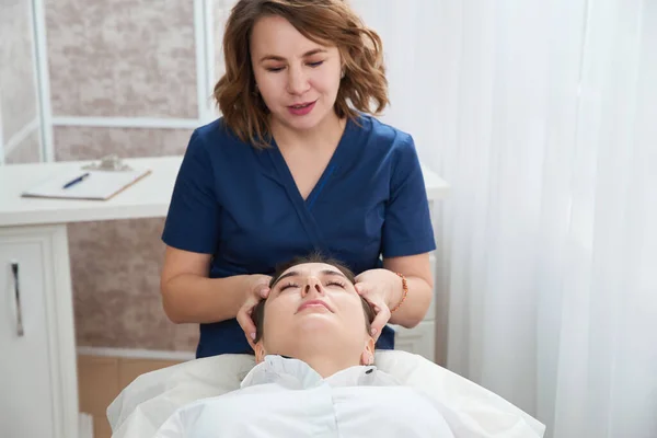 Beautiful Young Woman Getting a Face and head Treatment at Beauty Salon — Stock Photo, Image