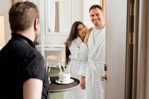 Oda servisi, bornoz giyen evli çiftler için otel odasına kahve getiriyor. — Stok fotoğraf
