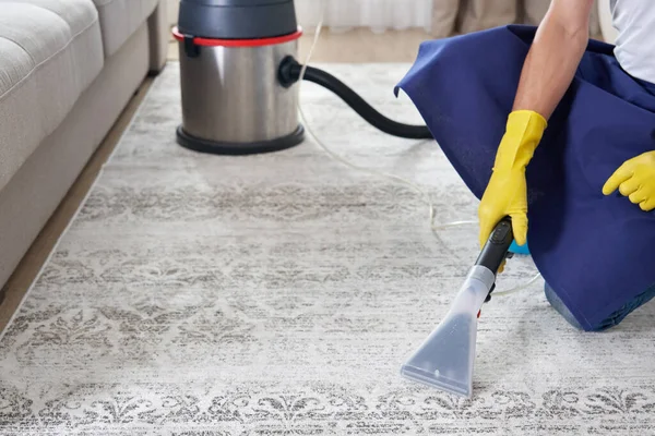 Man Cleaning Carpet In The Living Room Using Vacuum Cleaner At Home. Cleaning service concept — Stock Photo, Image