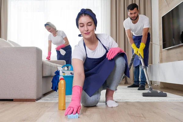 Professioneel schoonmaakteam reinigt woonkamer in modern appartement — Stockfoto