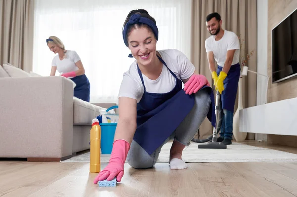 Professional cleaning service team cleans living room in modern apartment — Stock Photo, Image