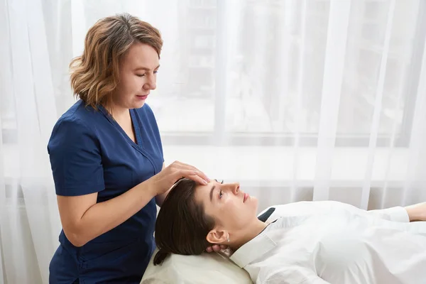 Hermosa mujer joven recibiendo un tratamiento de cara y cabeza en el salón de belleza — Foto de Stock