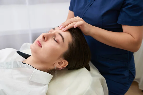 Belle jeune femme se faire traiter le visage et la tête au salon de beauté — Photo