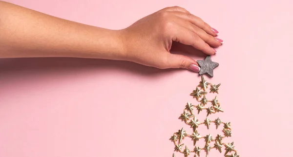 Weibliche Hände schmücken den Weihnachtsbaum auf rosa, Blick von oben. Flache Lage — Stockfoto