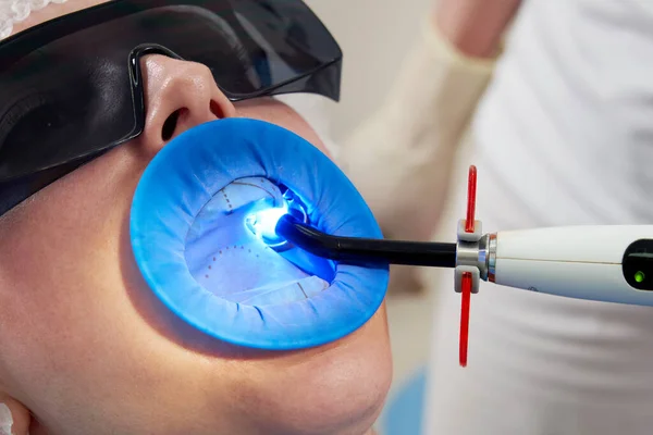 Paciente recibiendo tratamiento dental en el consultorio del dentista con protección de represas de goma dental — Foto de Stock