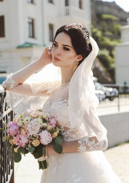 花の優しい香りと屋外ポーズのエレガントなウェディング ドレスに黒髪の美しい花嫁の写真をファッションします — ストック写真