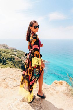 şık Plaj Giysi ve aksesuarları deniz kenarında cliff poz içinde koyu saçlı güzel şehvetli kız moda açık fotoğraf