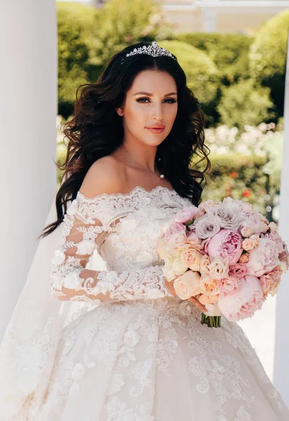 时尚户外照片美丽的新娘与深色的头发在豪华婚纱礼服 — 图库照片
