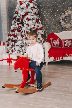küçük sevimli çocuk dekore edilmiş ev at oyuncakla oynamak tatil Noel fotoğraf