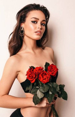 buket gül elinde tutan güzel seksi kadın zarif iç çamaşırı, siyah saçlı moda stüdyo fotoğrafı
