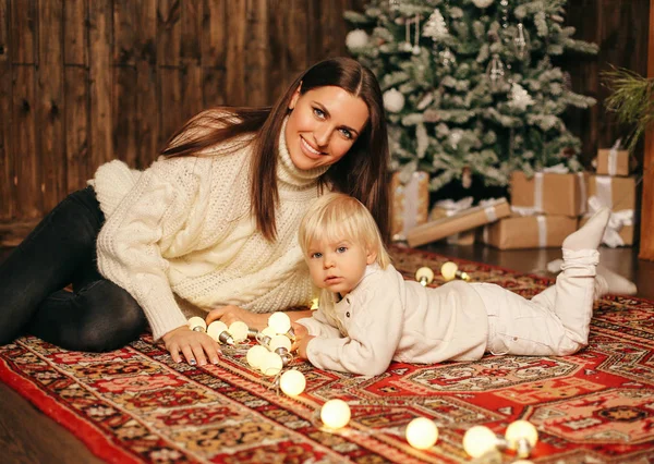 小さなかわいい男の子と装飾の家でおもちゃで遊んで彼の美しい母の休日のクリスマスの写真 — ストック写真