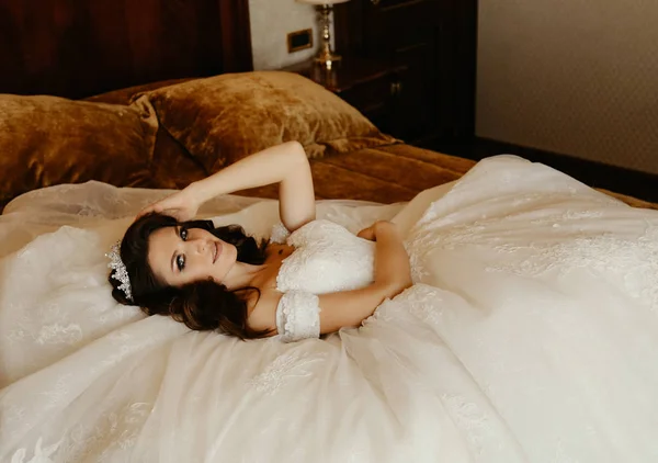 时尚内饰照片美丽的女人新娘 与黑头发在豪华的婚纱礼服摆在优雅的房间 — 图库照片