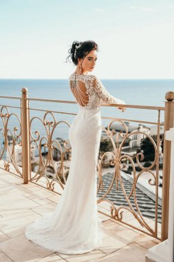 moda fotoğraf deniz manzaralı balkon poz lüks gelinlik siyah saçlı güzel kadın gelinin