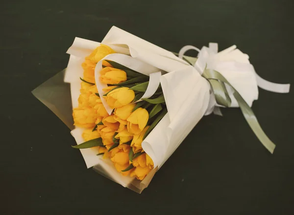 beautiful bouquet of yellow tulips in paper packaging
