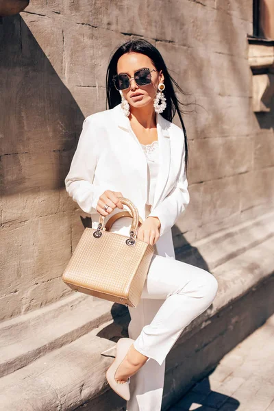 Mooie vrouw met donker haar in elegante witte pak en accesso — Stockfoto