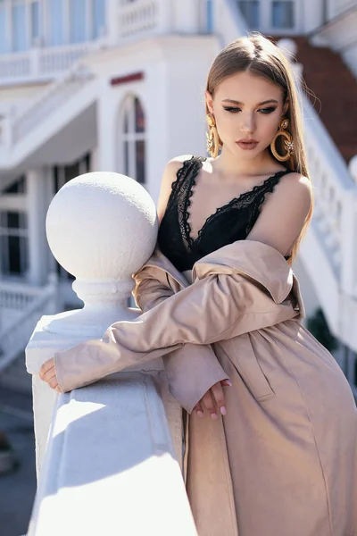 Beautiful woman with blond hair in elegant outfit walking by the — Stock Photo, Image