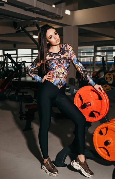 Vacker kvinna med mörkt hår i eleganta sportiga kläder Posin — Stockfoto
