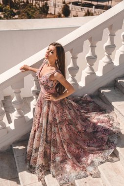 Uzun siyah saçlı, lüks gece elbisesi içinde güzel bir kadın. 