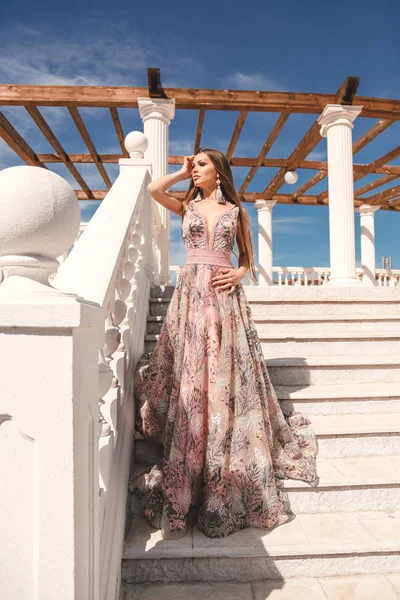 Beautiful woman with long dark hair in luxurious evening dress — Stock Photo, Image