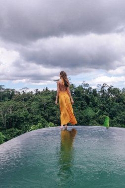 zarif sarı elbise li koyu saçlı güzel kadın poz