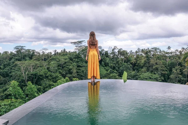 Schöne Frau mit dunklen Haaren in elegantem gelben Kleid posiert auf — Stockfoto